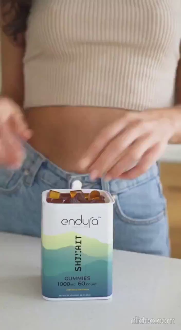 Hand opening a tin of Endura shilajit gummies on a kitchen counter